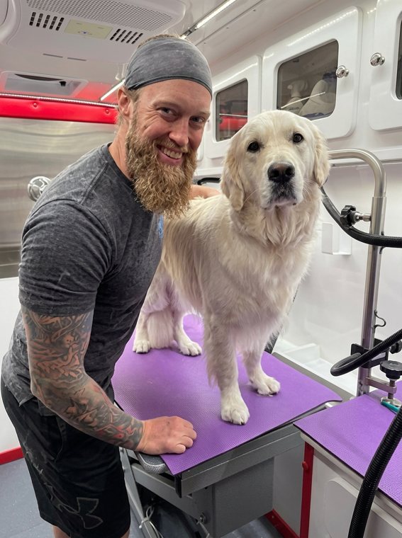 Scott with a freshly groomed golden retriever in his mobile grooming van serving Georgetown, TX