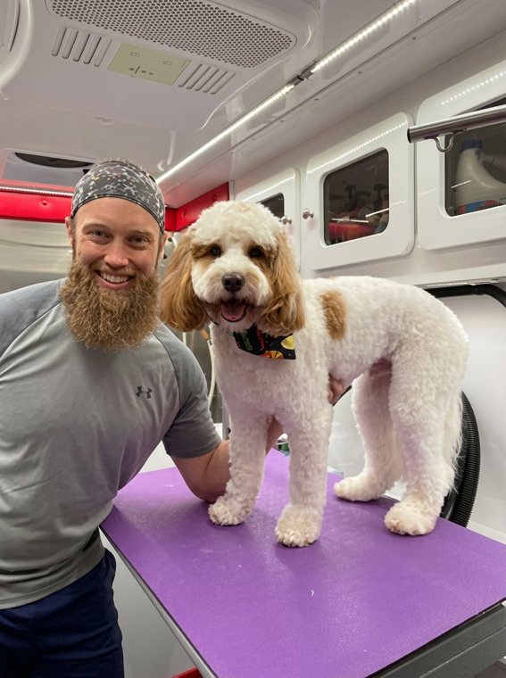 Scott with a freshly groomed doodle in his mobile dog grooming van in Round Rock, TX